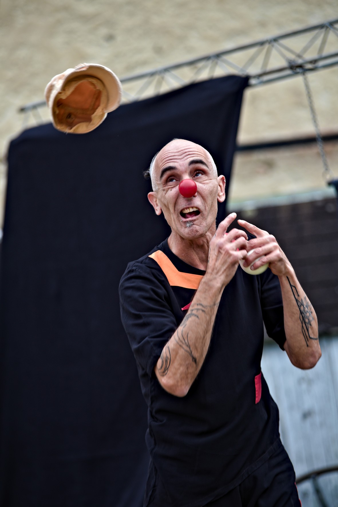 Tommy en costume et avec son nez rouge s'essaie à la jonglerie dans le spectacle comique de clown mutation